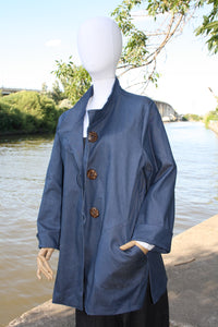 Blue organic denim jacket. Loose fit. Cuffed sleeve. 3 button closure.  2 large pockets. Hip length.